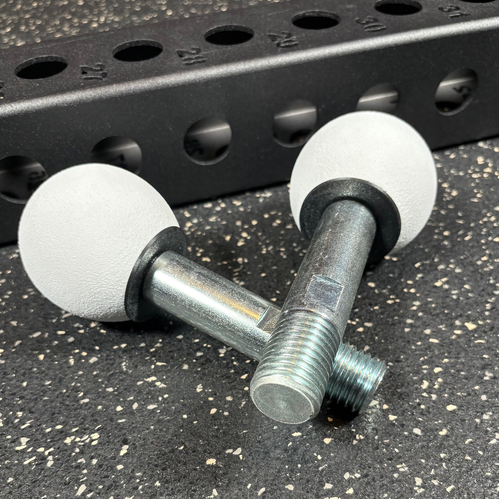 Two white spherical climbing holds for squat rack attachments and crossmember