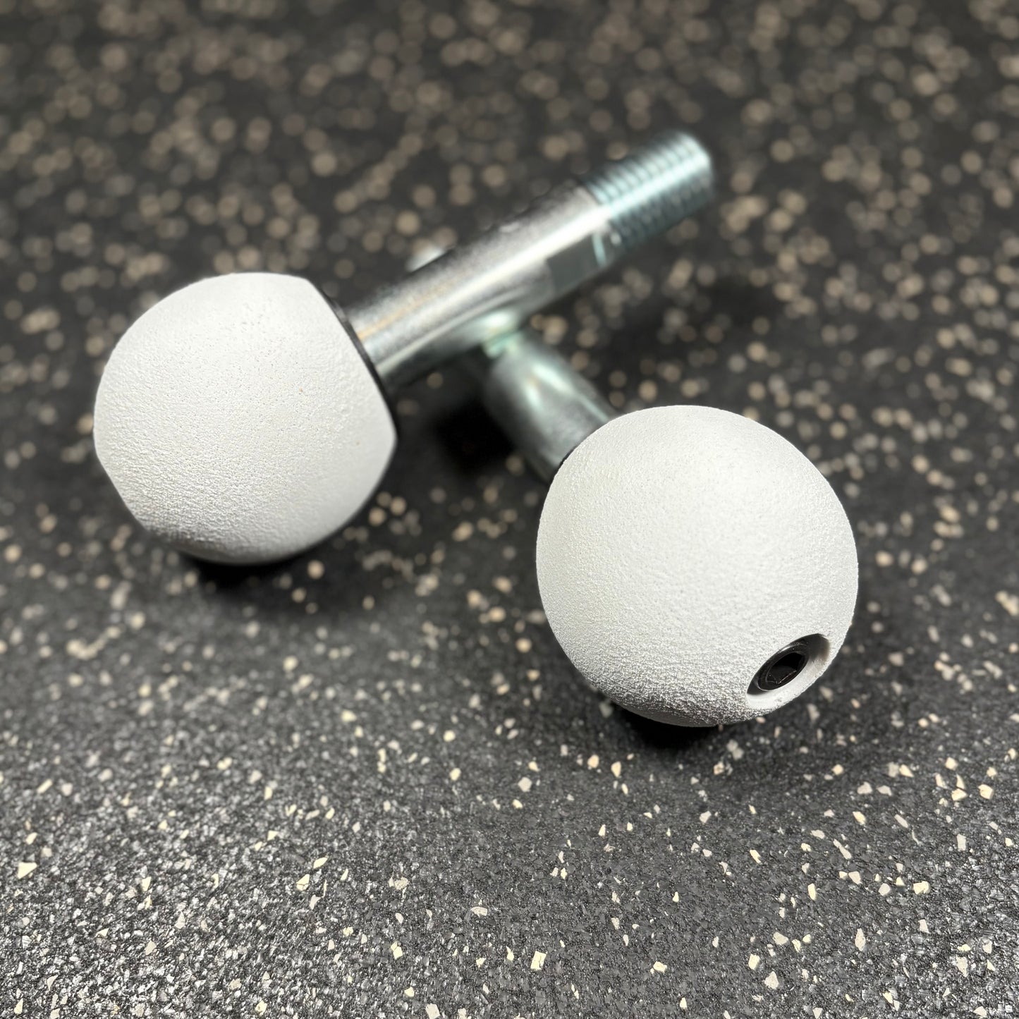 Two white spherical climbing holds for squat rack attachments 